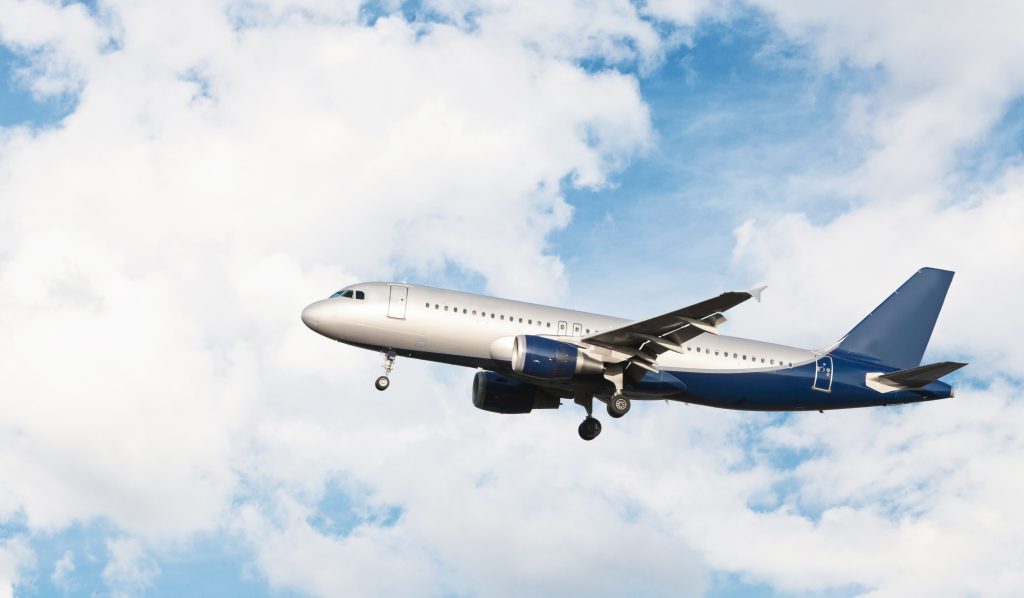 airplane-flying-cloudy-sky-min