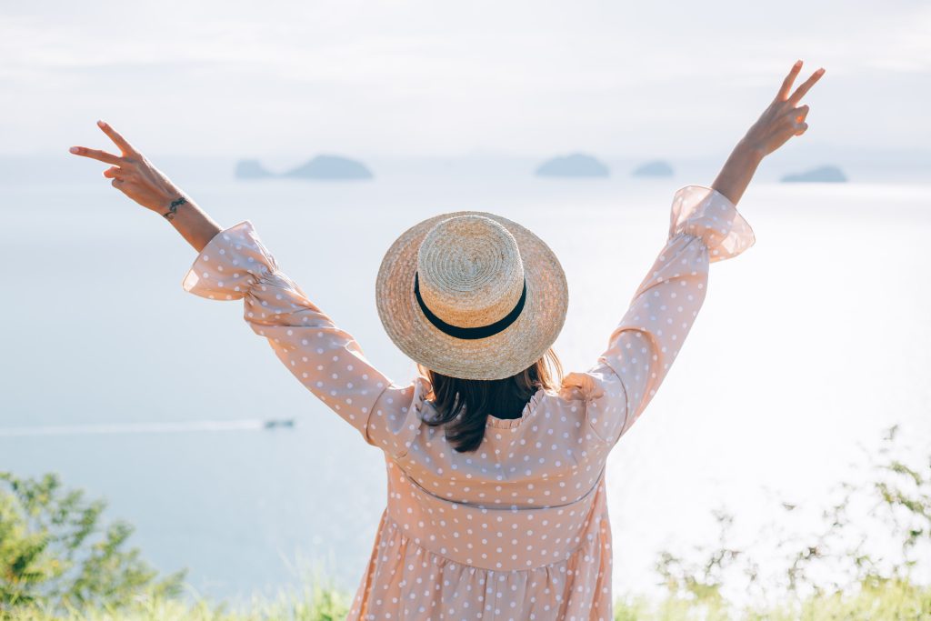 happy-woman-summer-cute-dress-straw-hat-vacation-with-tropical-exotic-views-min